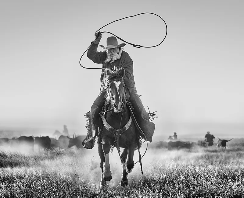 photograph of a cowboy roping on a horse by David Yarrow